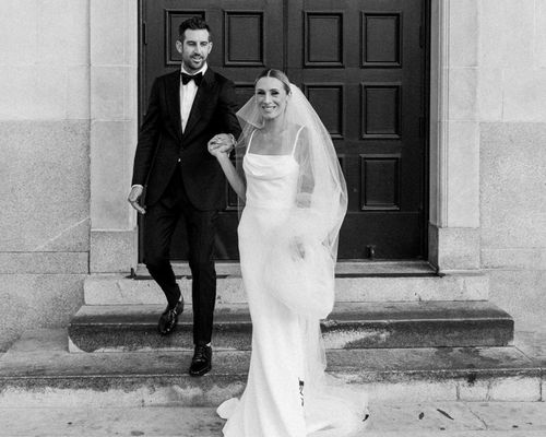 bride and groom holding hands in front of a door