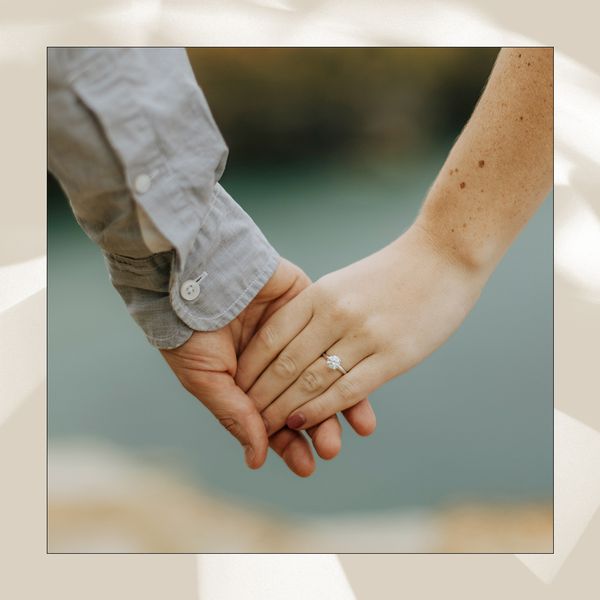 Close Up of Couple Holding Hands and Woman Wearing Diamond Engagement Ring