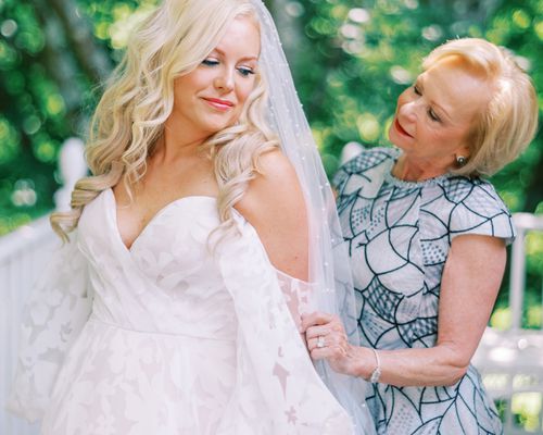 Mother of the Bride in Blue Dress and Daughter in Veil Posing for Photo 