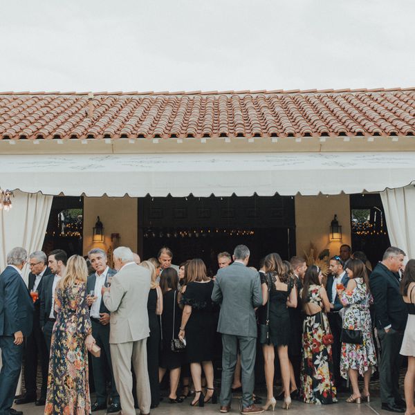 wedding guests under pergola at cocktail hour