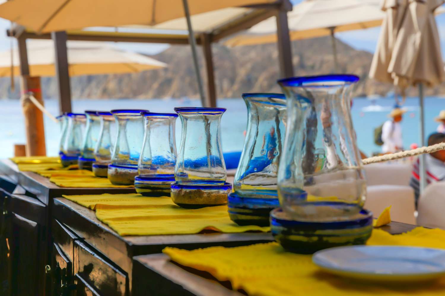Rustic water jugs lined up along a patio serving table at a Mexican restaurant in Cabo San Lucas Mexico
