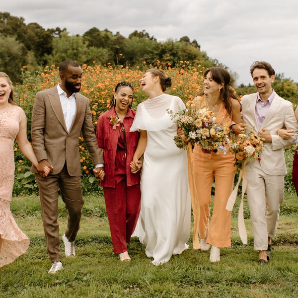 Bride and Wedding Party in Mismatched Attire Walking Through Flower Field