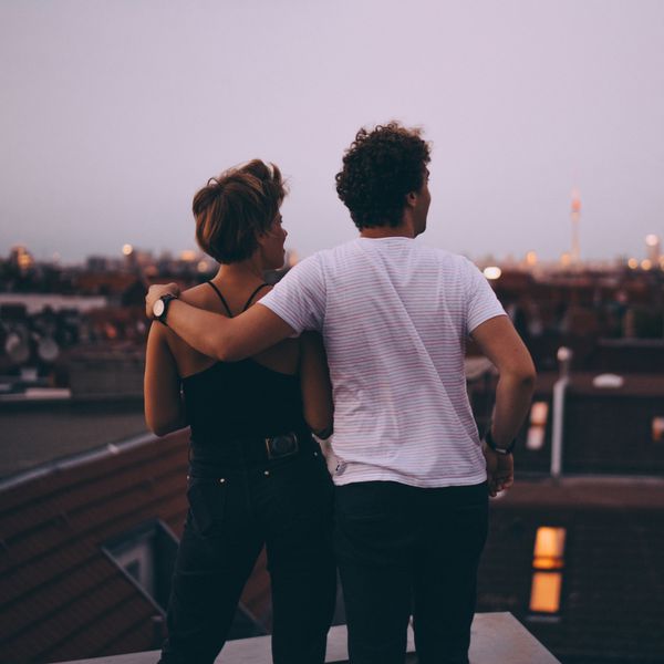 Man and Woman Standing on a Rooftop Overlooking City Skyline