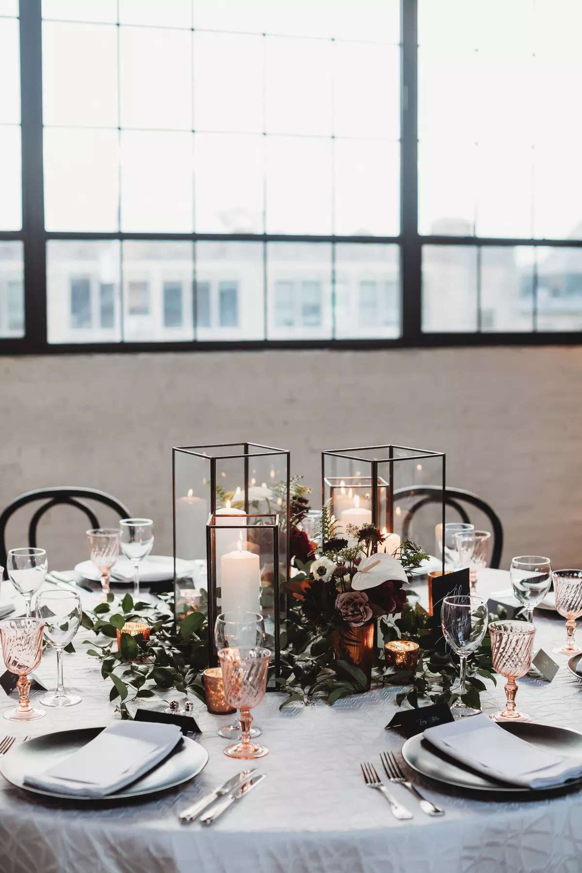 black lantern centerpieces on reception tables with pink glassware and flowers