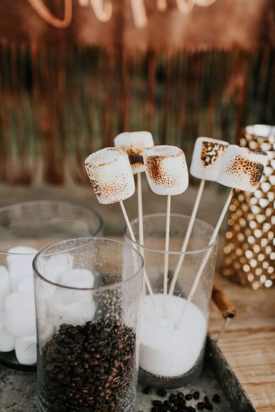 Marshmallows on sticks in a glass cup