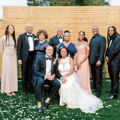 bride and groom posing for a fall wedding photo with their family