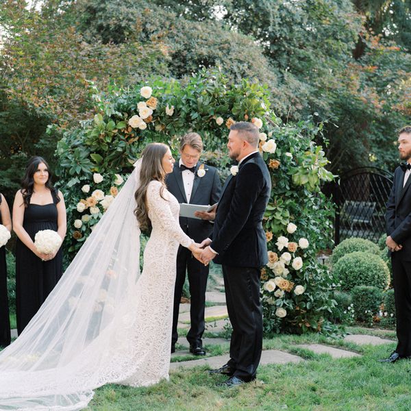 Bride and Groom Holding Hands While Exchanging Wedding Vows at Outdoor Wedding Ceremony