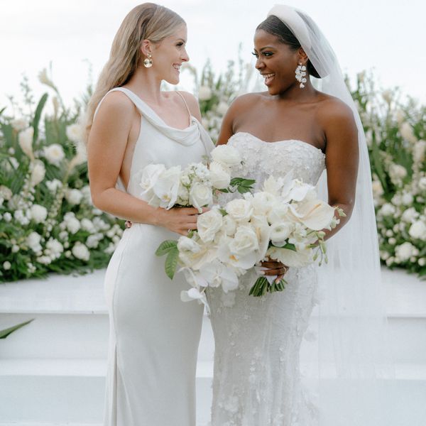 a bride and maid of honor looking and smiling at each other