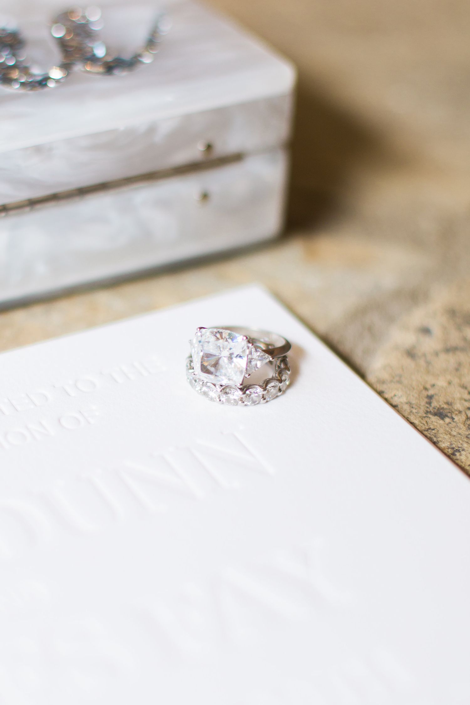 cushion-cut engagement ring sitting on a diamond pave band