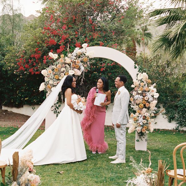 friend in pink dress officiating a bride and groom's ceremony