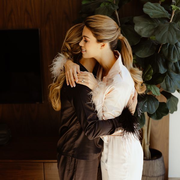 a bride and her maid of honor hugging while wearing pajamas