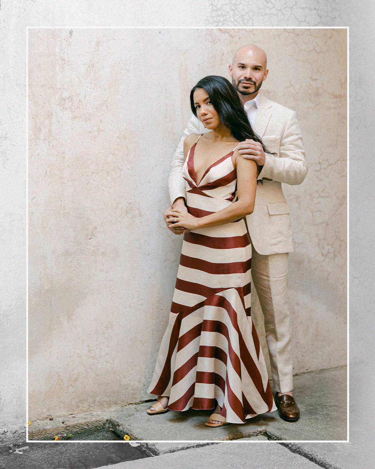 women wearing a striped slip dress and a man wearing a tan suit