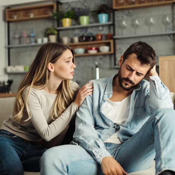 Young woman pleading with her boyfriend at home