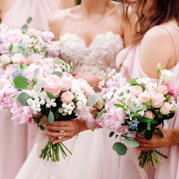 bride and bridesmaids in pink dresses carrying lush bouquets