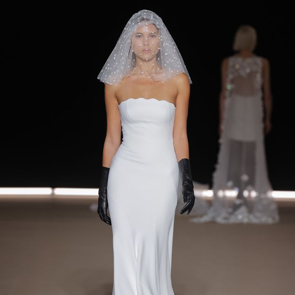 runway model wearing a strapless wedding dress, pearl-embellished blusher veil, and black gloves 