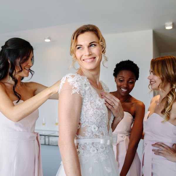 bride with three bridesmaids in pink dresses getting ready on the morning of the wedding