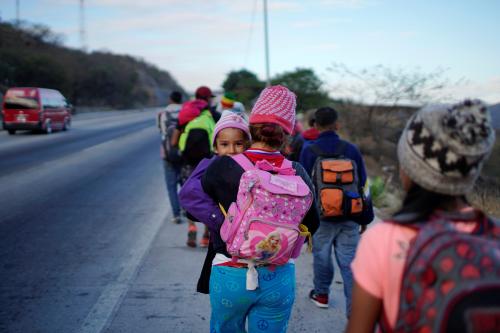 Five years old Soe Morales peers to the camera while being carried by her mother during their journey towards the United States, in Guastatoya, Guatemala, January 17, 2019. REUTERS/Alexandre Meneghini - RC1421FAAAC0