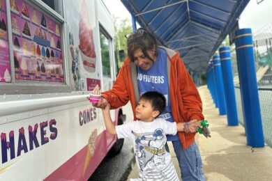 A BCCS teacher and student receive ice cream from the ice cream truck.