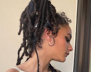 The actor Sasha Lane in profile, her dreadlocks piled into a chic ponytail