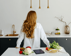 A woman's back in a kitchen with long flowing hair