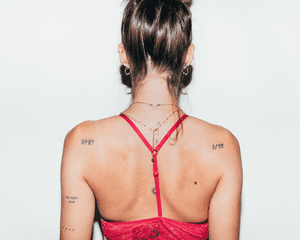 A woman's back with lots of piercings and tattoos