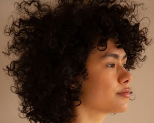 young woman in profile with curly hair