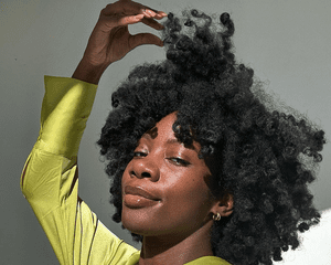 woman feeling her curly hair on white background