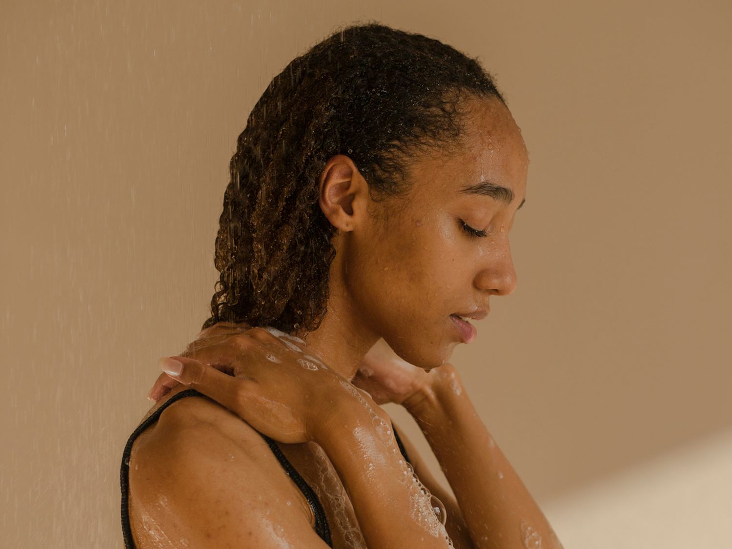 Woman with wet curly hair in shower