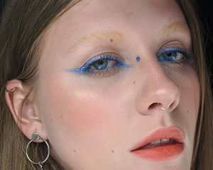 close-up of woman with bridge piercing and blue eyeliner