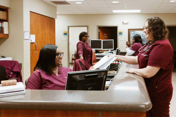 A CIS doctor in a white coat and stethoscope talking with a cardiovascular patient