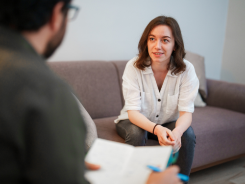 A woman listens to her therapist talk about medication-assisted treatment for opioid use disorder.