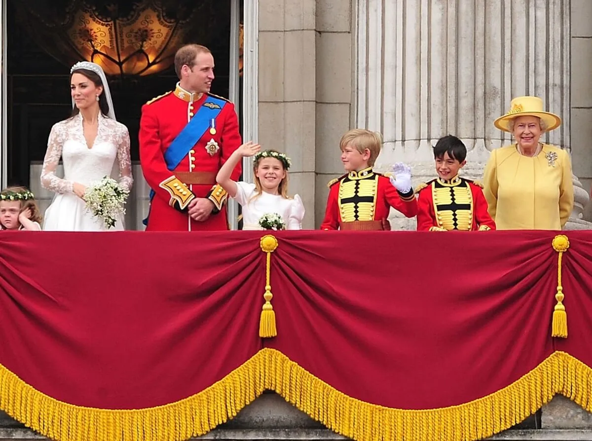 Queen Elizabeth II standing on the balcony of Buckingham Palace with Prince William and Kate Middleton following their royal wedding