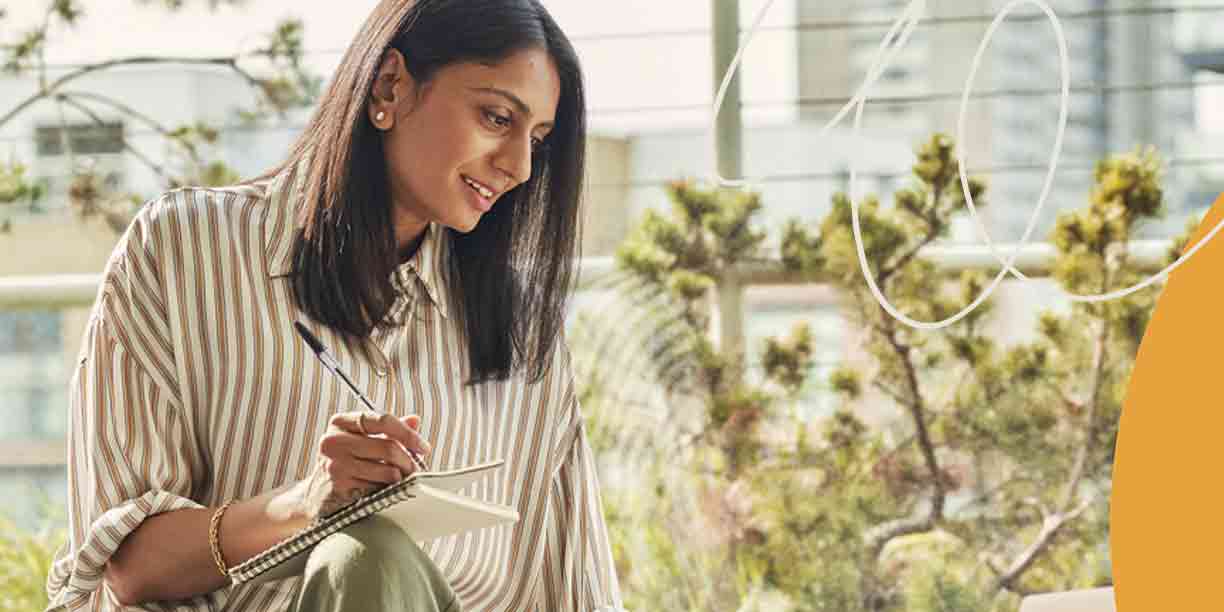 woman in stripes writing in notebook