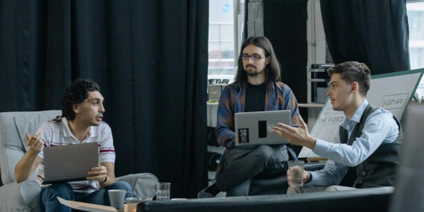 Co-workers sitting in office lounge discussing workplace giving programs