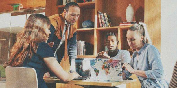 group of men and women working on shared laptops