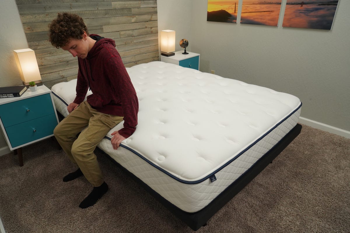 CNET mattress expert testing the edge support of the GravityLux mattress.