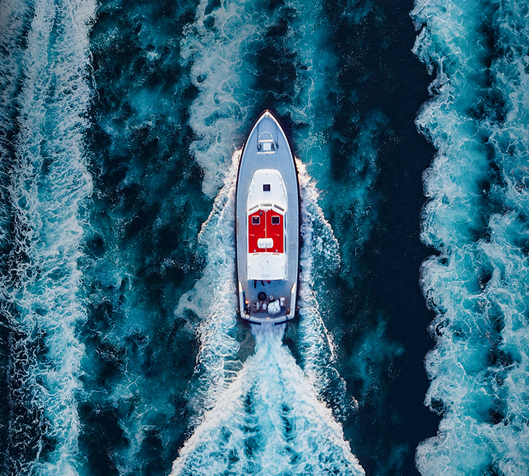 Aerial view of motorboat speeding over waves