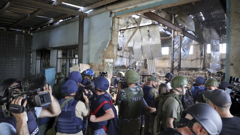 Journalists visit the destroyed barracks at the Russian-controlled Olenivka prison holding Ukrainian POWs in eastern Ukraine, on Aug. 10, 2022. (AP Photo/File)