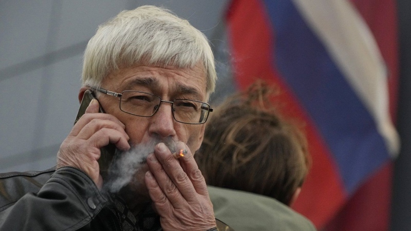 Oleg Orlov, co-chair of the Nobel Peace Prize-winning human rights group Memorial, speaks by phone after a court hearing in Moscow, Russia, on Oct. 7, 2022. (AP Photo/Alexander Zemlianichenko, File)