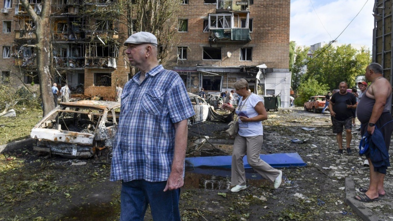 People walk near an apartment building damaged after shelling by the Ukrainian side, in Kursk, Russia, Sunday, Aug. 11, 2024. (Uncredited AP Photo)