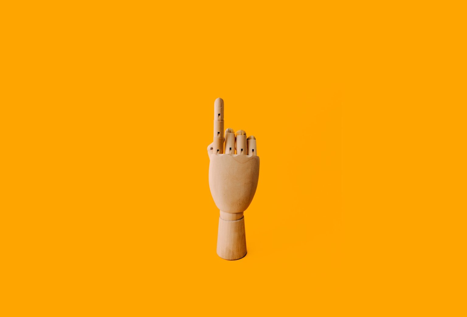 wooden hand on yellow background keyboard flicks