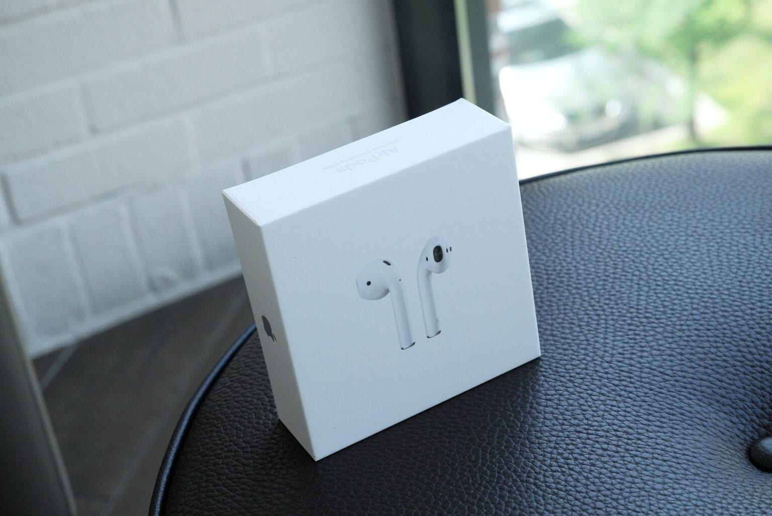 An unopened AirPods box on a table.