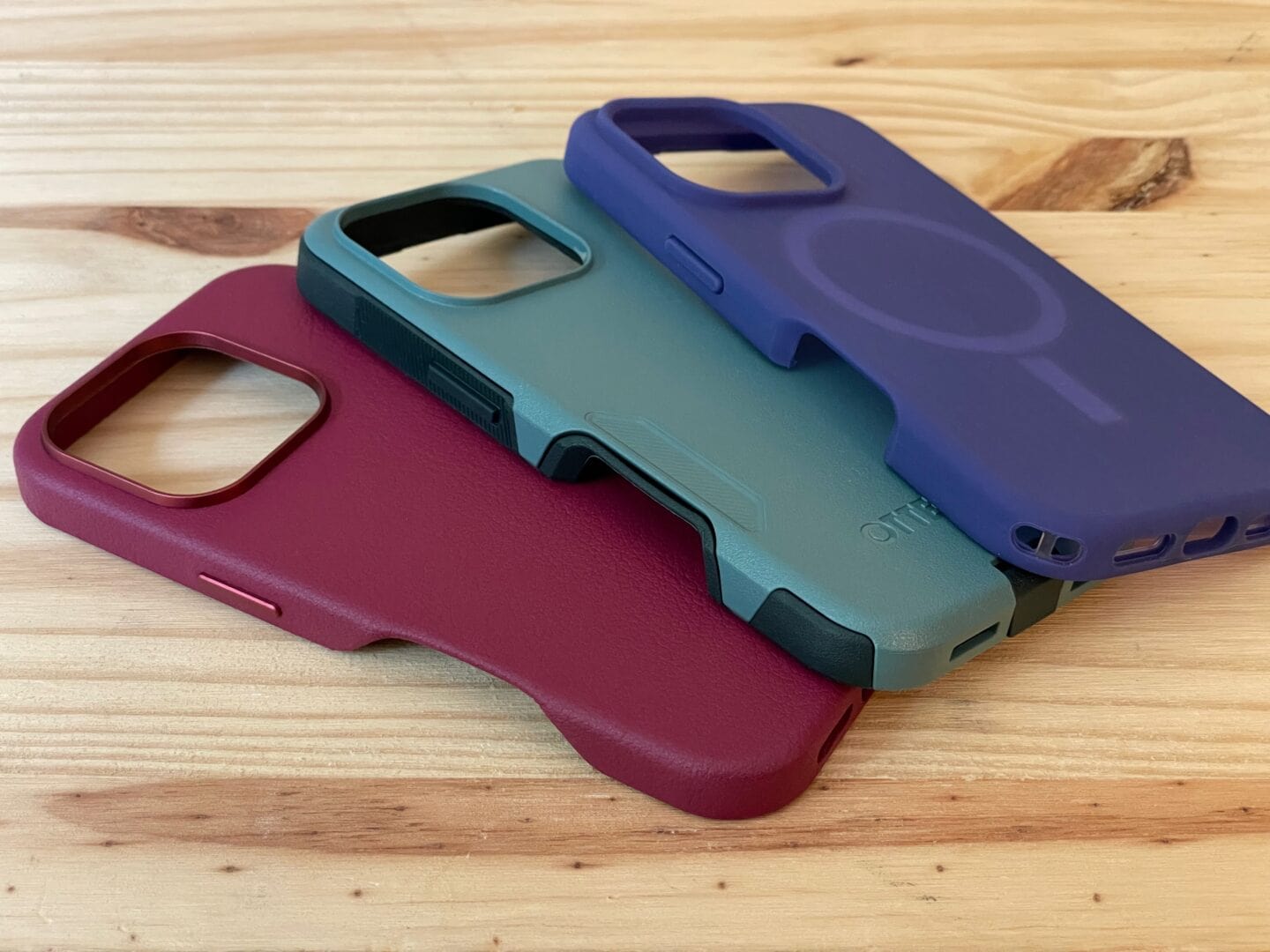 Stack of three OtterBox cases in different styles and colors, each with a large cutout in the side for the Camera Control.