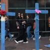 People walk by large crosses are on a sidewalk on Bourbon Street in New Orleans.