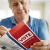 An elderly man votes.