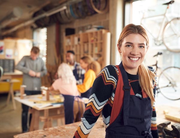 Peninsula Group Limited - Retail worker smiling at camera while colleagues work behind them