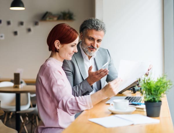 Peninsula Group Limited - Two office workers sharing notes at a desk