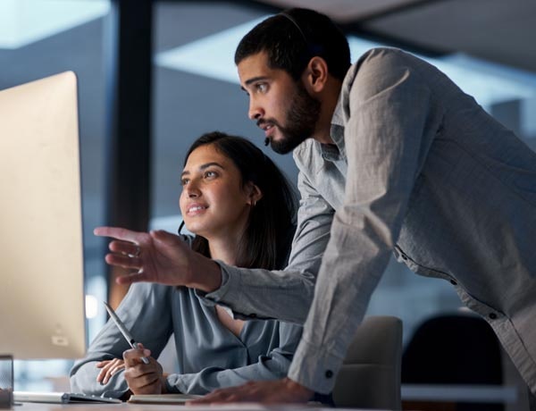 Peninsula Group Limited - An manager guiding an employee through an issue on their computer