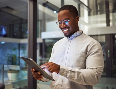 Peninsula Group Limited - An employee smiling as they check their tablet in a office setting