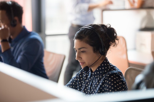 Woman working at a desk speaking into a headset